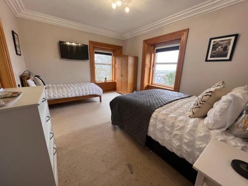 a bedroom with a bed and a desk in it at Morven Guest House Carnoustie in Carnoustie