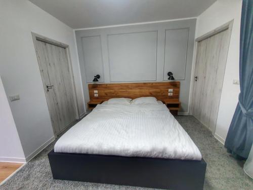 a bedroom with a large bed with white sheets at Vily Luxury Rooms in Focşani