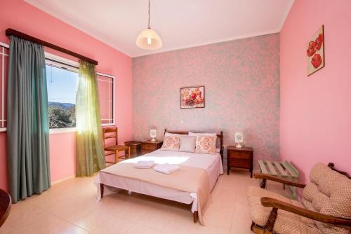 a bedroom with pink walls and a bed and a window at marina's home in village in Kornáta