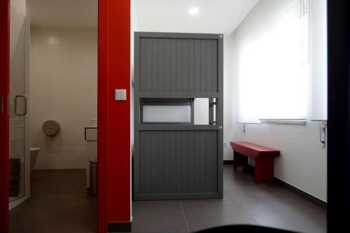 una porta in una stanza con una parete rossa di Lab Hostel Nazare a Nazaré