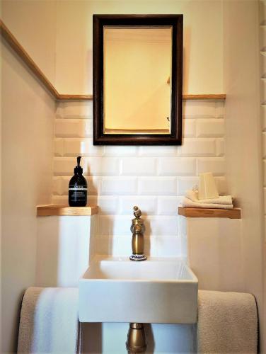 a bathroom with a white sink and a mirror at Le Neptune in Le Somail