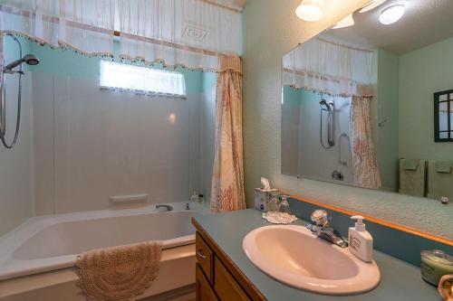 a bathroom with a sink and a bath tub at Turtle Rocks Oceanfront Inn in Trinidad