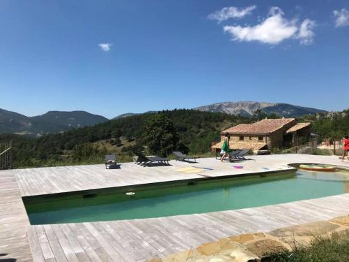 une maison avec piscine avec des montagnes en arrière-plan dans l'établissement Vues et nature exceptionnelles au coeur de 200 ha pour 16 pers, à Teyssières
