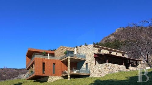 un bâtiment sur une colline avec une montagne en arrière-plan dans l'établissement Vues et nature exceptionnelles au coeur de 200 ha pour 16 pers, à Teyssières