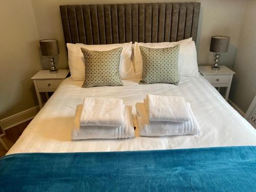 a bed with three pillows on top of it at Luxury Riverside City Centre Apartment in York