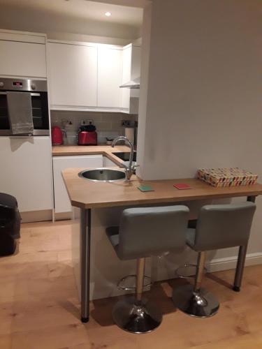a kitchen with a sink and a table with chairs at Jaskar studio 2 in Cheltenham