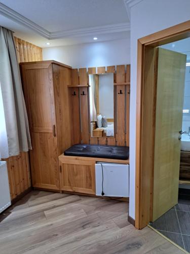 een kamer met houten kasten, een bed en een spiegel bij Lake House in Jezerce