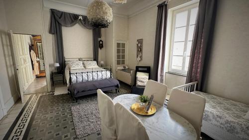 1 dormitorio con 1 cama, mesa y sillas en Le Neptune en Le Somail