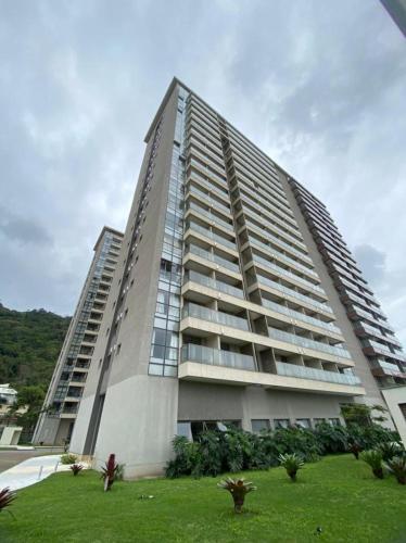a large apartment building with a green lawn in front of it at Flat Premiere Rio Centro in Rio de Janeiro