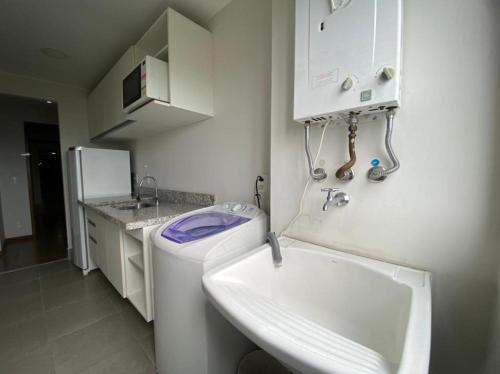 a small kitchen with a sink and a washing machine at Flat Premiere Rio Centro in Rio de Janeiro