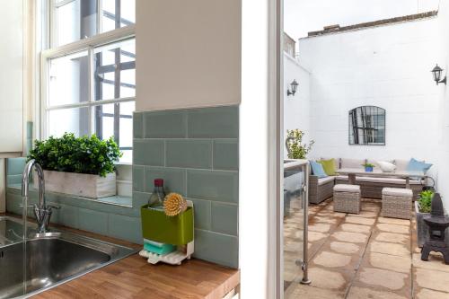 uma cozinha e sala de estar com um lavatório em Kensington Nest Serviced House em Londres