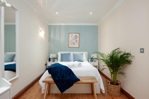 um quarto com uma cama e um vaso de plantas em Kensington Nest Serviced House em Londres