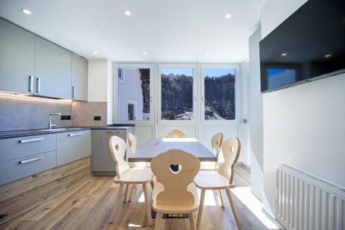 a kitchen and dining room with a table and chairs at Dolomites Apartments Cesa Benedet in Santa Cristina in Val Gardena
