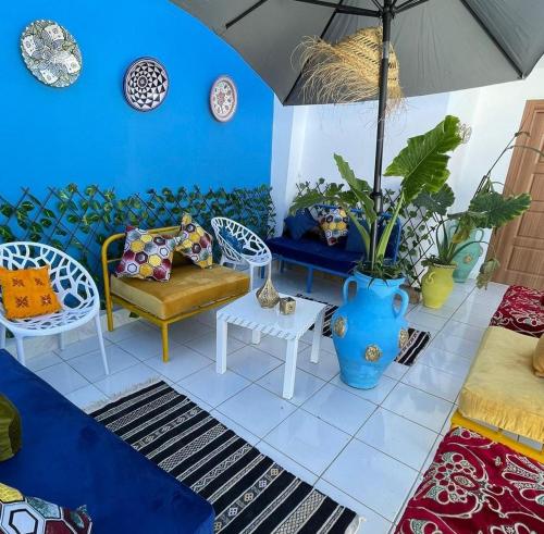 a living room with a couch and chairs and an umbrella at Hotel Palace tanger in Tangier