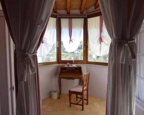 a room with a desk and a window with curtains at Agriturismo Tara in Amelia