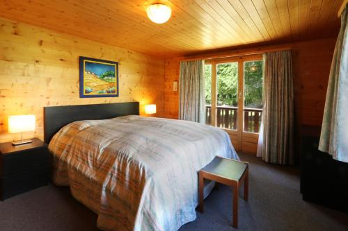 a bedroom with a large bed and a window at Chalet les Mayens in Saas-Fee