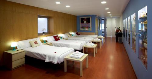 a row of beds in a room with tables at Apartamento Granollers in Granollers