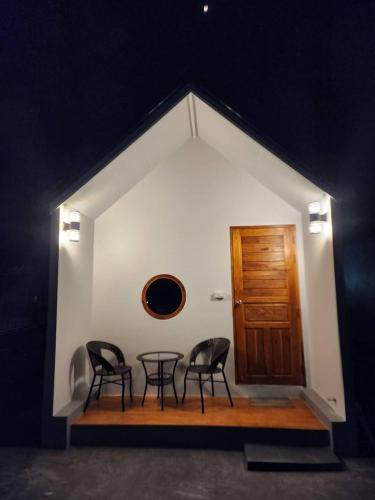 a room with two chairs and a table and a door at Bunrapee House in Nan