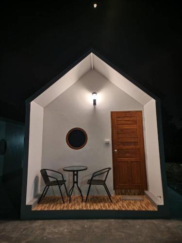 a room with a table and two chairs and a door at Bunrapee House in Nan