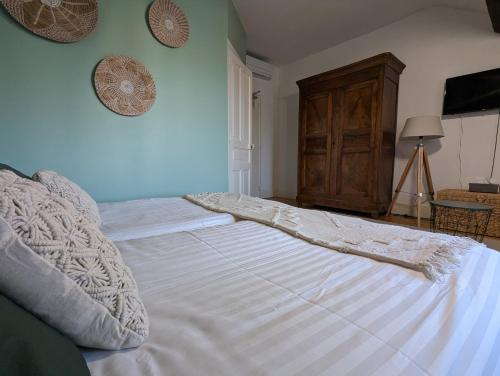 a bedroom with a large bed with white sheets at Logis Hotel La Tourelle du Beffroi in Bourbon-Lancy
