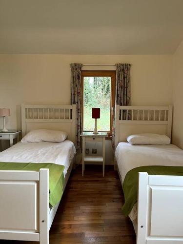 1 dormitorio con 2 camas y ventana en Ballyhoura Forest Home, en Ballyorgan