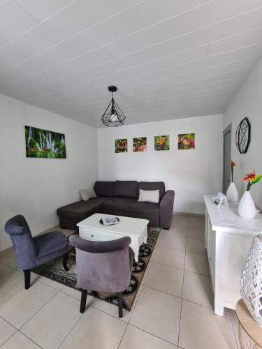 een woonkamer met een bank en een tafel bij Gîte la Belle Vallée maison indépendante 80m2, 2 chambres à 10 min du Puy du Fou in Treize-Vents