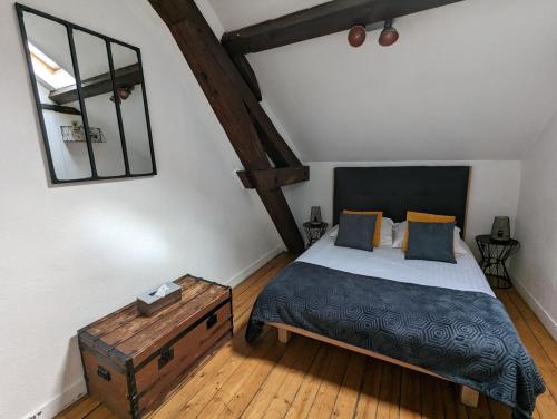 a bedroom with a bed and a wooden floor at Logis Hotel La Tourelle du Beffroi in Bourbon-Lancy