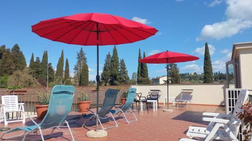 een groep stoelen en parasols op een patio bij Villa Gelsomino Garden in Florence