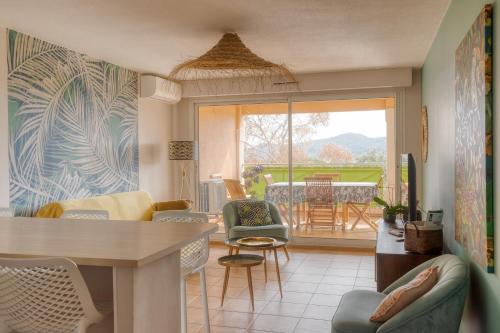 un soggiorno con tavolo e sedie di Bel appartement classé 3 étoiles a Bormes-les-Mimosas