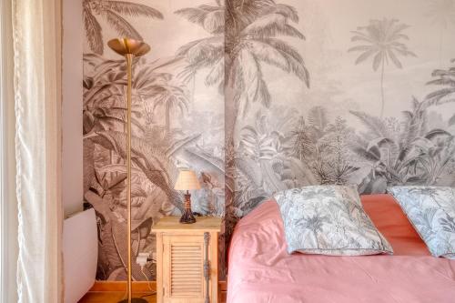 una camera da letto con un letto e carta da parati a palma di Bel appartement classé 3 étoiles a Bormes-les-Mimosas
