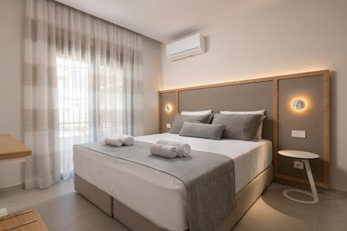 een slaapkamer met een groot bed met twee handdoeken erop bij Stylish Rhodes Apartment with Prime Location - L & C City Escape in Rhodos-stad