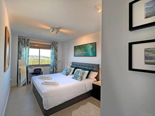 1 dormitorio con cama y ventana grande en Baviera Hills Holiday Apartment en Caleta de Vélez