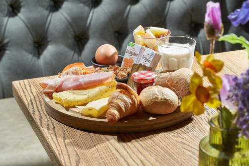 a tray of food on a table with bread and eggs at Boutique Hotel Brasa Beemster in Middenbeemster