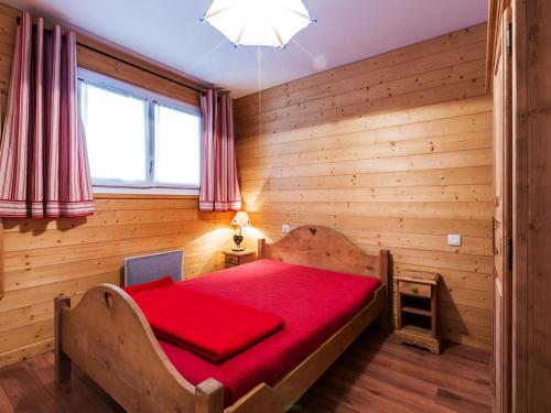 Cette chambre en bois comprend un lit rouge. dans l'établissement Appartement familial au pied des pistes, 3 chambres, 2 salles de bain, garage - Proche village - FR-1-437-34, à La Clusaz