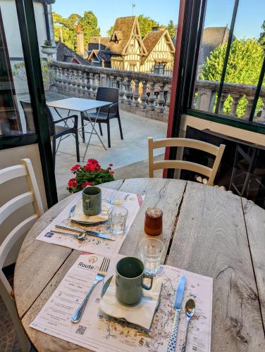 a wooden table with two cups on top of it at Logis Hotel La Tourelle du Beffroi in Bourbon-Lancy