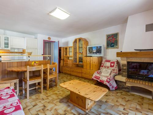 un salon avec une table et une cheminée dans l'établissement Appartement cosy, proche pistes et centre, 3 pièces, 6 pers, cheminée, balcon, parking - FR-1-437-53, à La Clusaz
