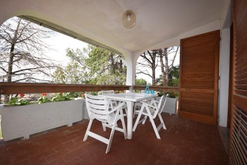 - Balcón con mesa blanca y sillas en Villa Noemi, en Scarlino
