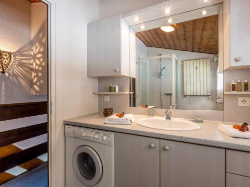 une salle de bain avec une machine à laver et un lavabo dans l'établissement Duplex 2 chambres au centre du village, proche pistes de ski, parking inclus, La Clusaz - FR-1-437-40, à La Clusaz