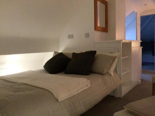a bedroom with a white bed with black pillows at Prestatyn Loft in Prestatyn