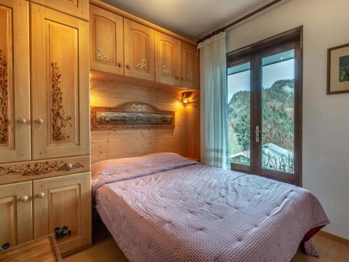 a bedroom with a bed and a large window at Appartement La Clusaz, 3 pièces, 6 personnes - FR-1-437-44 in La Clusaz