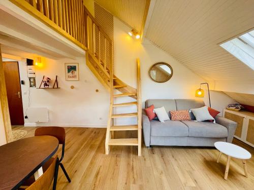 un salon avec un canapé et un escalier en colimaçon dans l'établissement Charmant appartement idéalement situé, à Saint-Lary-Soulan