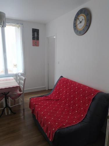 un salon avec un canapé et une horloge au mur dans l'établissement Les marmottes du Sancy, à Le Mont-Dore