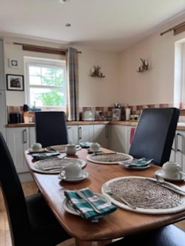 a kitchen with a wooden table with chairs around it at Pinewood Country House in Leuchars