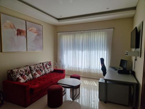 a living room with a red couch and a window at Ferienhaus in Paraguay, Encarnacion, 200 Meter vom Parana. in Encarnación