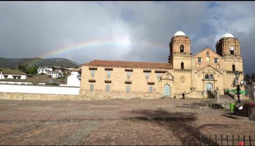 an old building with a rainbow in the background at Hotel Portón De Ocetá in Monguí