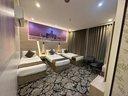 a hotel room with two beds and a painting on the wall at فندق اسكنت الحفاير - Askant Al Hafayer Hotel in Makkah