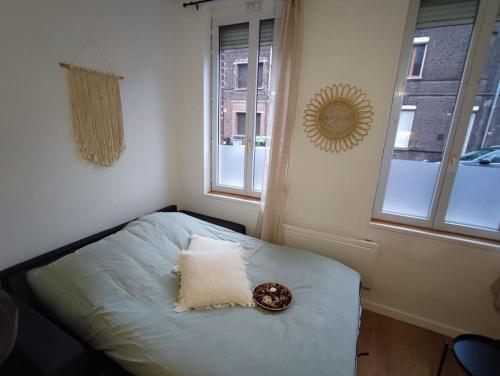 1 dormitorio con 1 cama con almohada y 2 ventanas en Namaste Studio by T&L, en Denain