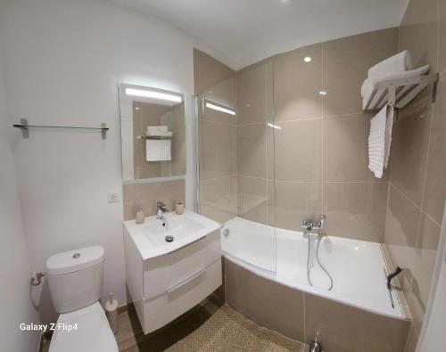 a bathroom with a tub and a toilet and a sink at Charmant studio vue mer / parking / plage à 200m in Bastia