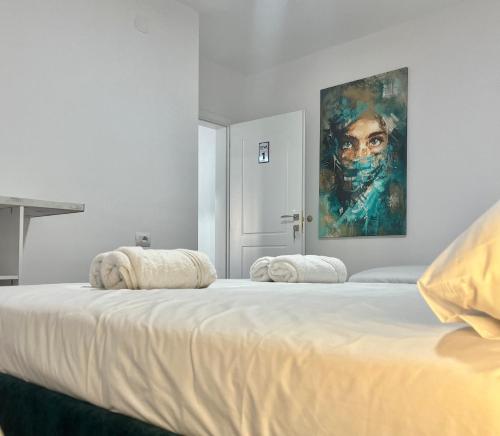 1 dormitorio con 2 camas y un cuadro en la pared en Viva apartments, en Përmet