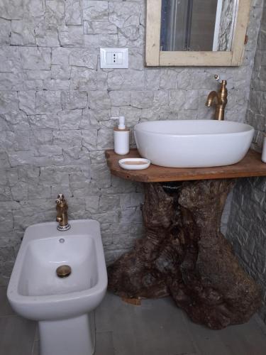 a bathroom with a sink and a white toilet at Casale Tano in Pachino